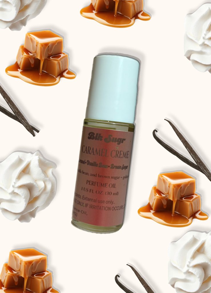 A bottle of Blk Sugr “Caramel Crème” perfume oil placed on a creamy beige background, surrounded by melting caramel cubes, vanilla beans, and whipped cream. The label notes include caramel, vanilla bean, and brown sugar.