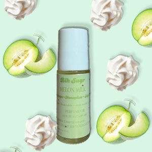 A bottle of Blk Sugr “Melon Milk” perfume oil placed on a mint green background, surrounded by sliced honeydew melon and soft whipped cream swirls. The label highlights notes of cantaloupe, honeydew, and clean musk.
