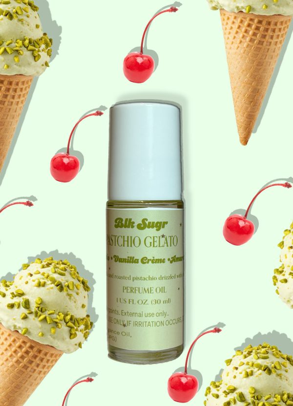 A bottle of Blk Sugr “Pistachio Gelato” perfume oil on a pale mint green background, surrounded by pistachio ice cream cones and red maraschino cherries. The label highlights pistachio, vanilla crème, and amaretto notes.