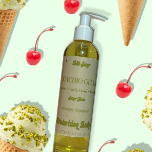 A bottle of Blk Sugr “Pistachio Gelato” Sugr Glaze body oil on a mint green background, surrounded by pistachio ice cream cones and maraschino cherries. The label includes notes of pistachio, vanilla crème, and amaretto.
