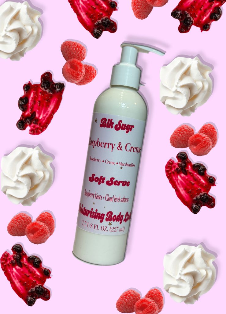 A bottle of Blk Sugr Raspberry & Creme Soft Serve Lotion on a pink background with fresh raspberries, raspberry jam swirls, and whipped cream dollops.