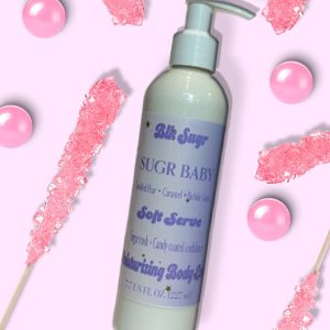 A bottle of Blk Sugr Sugr Baby Soft Serve Lotion on a candy pink background with bubblegum balls and pink rock candy.
