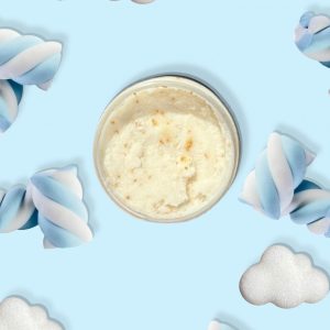 A jar of Blk Sugr Blue Marshmallow Clouds Sugr Buff body scrub on a baby blue background surrounded by fluffy white clouds and twisted blue & white marshmallows.